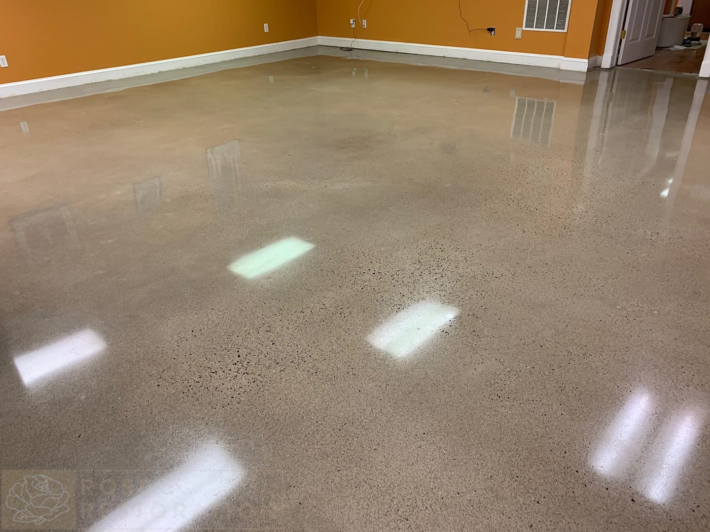 Polished Concrete floor, some exposed aggregate, mirror like finish reflecting lights and walls.